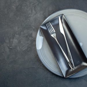 vista superior plato largo negro tenedor cuchillo plato gris sobre fondo oscuro cubiertos vidrio colorido feminidad comida cocina horizontal 140725 156861